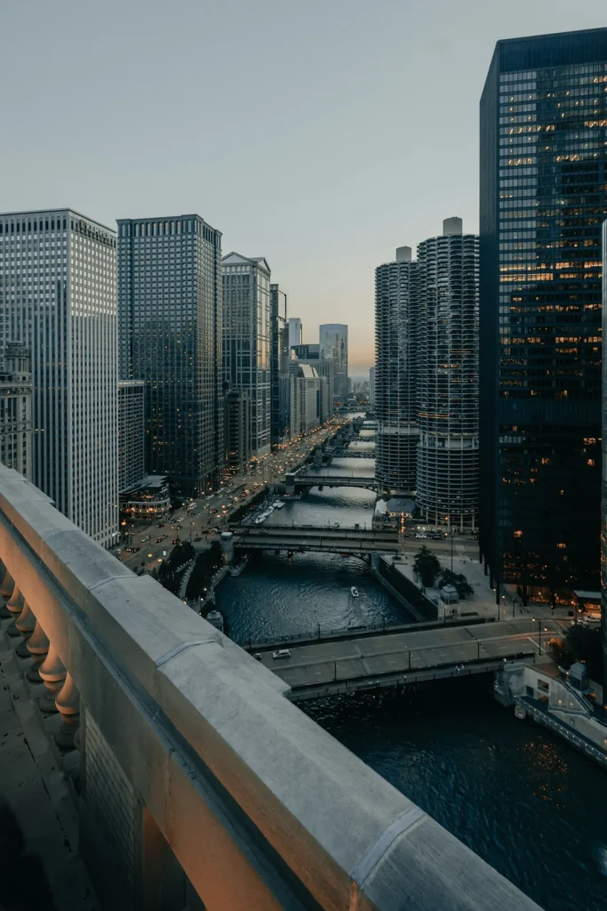Chicago River flanked by skyscrapers and Marina City towers at dusk, viewed from above
