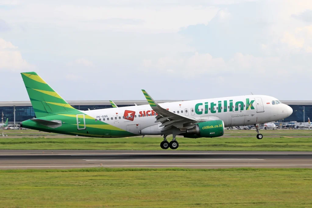 Citilink Airbus A320 airplane touching down on an airport runway