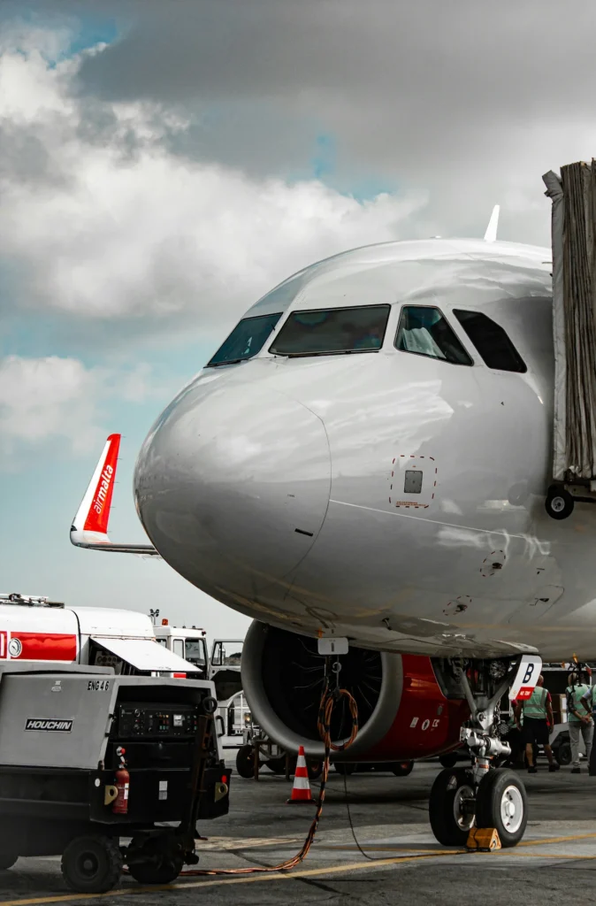 Close-up of a white commercial airplane nose parked at an airport terminal gate