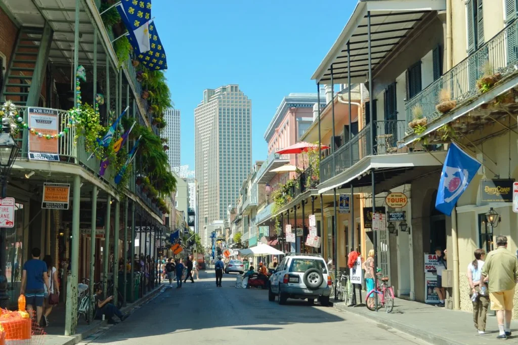 Street view of the French Quarter in New Orleans with historic balconies and a skyscraper in the distance