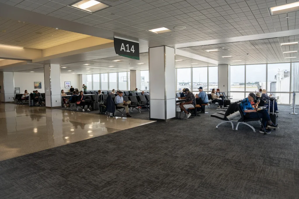 Passengers waiting in the departure seating area by gate A14 inside IAH airport
