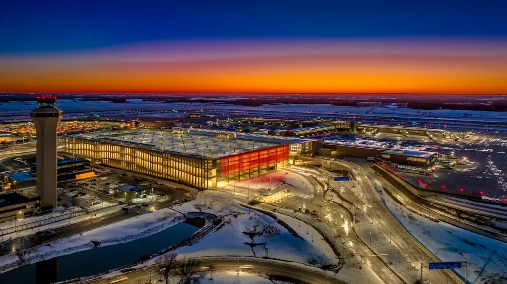 An aerial sunset view of the modern terminal and parking structure at Kansas City International Airport