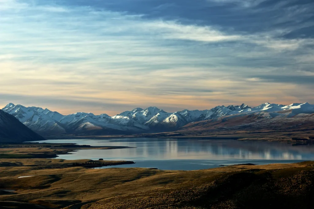 Snowy Southern Alps mountain peaks reflecting on Lake Tekapo in New Zealand