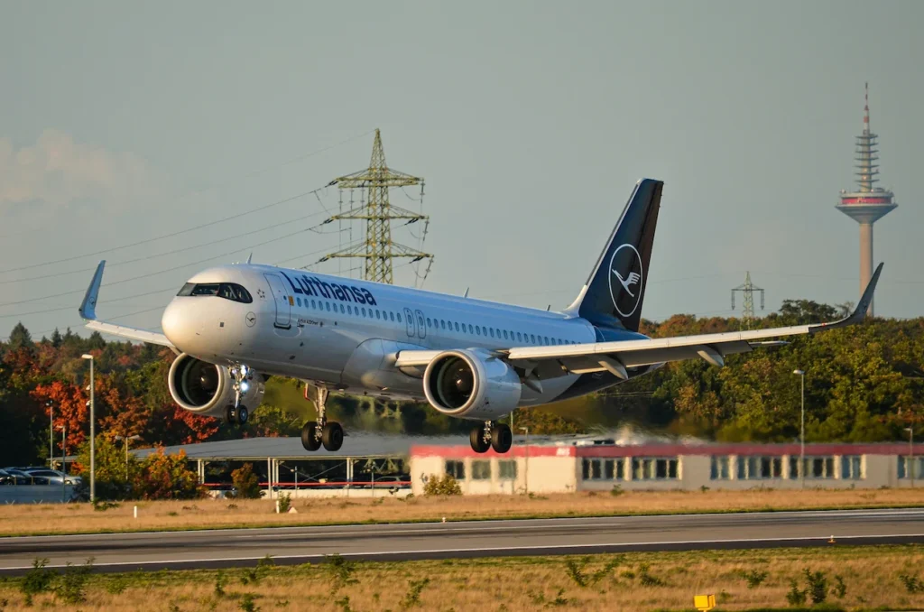 Lufthansa Airbus A321neo passenger plane descending low over the runway with a communications tower background
