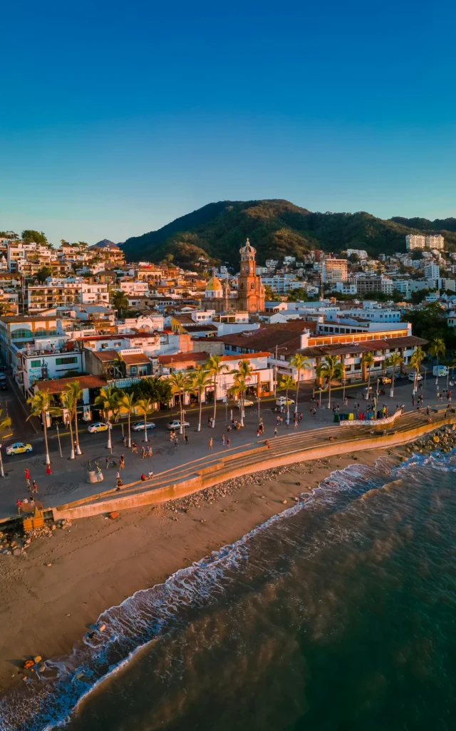 Aerial view of the Puerto Vallarta boardwalk, beach, and historic church at sunset