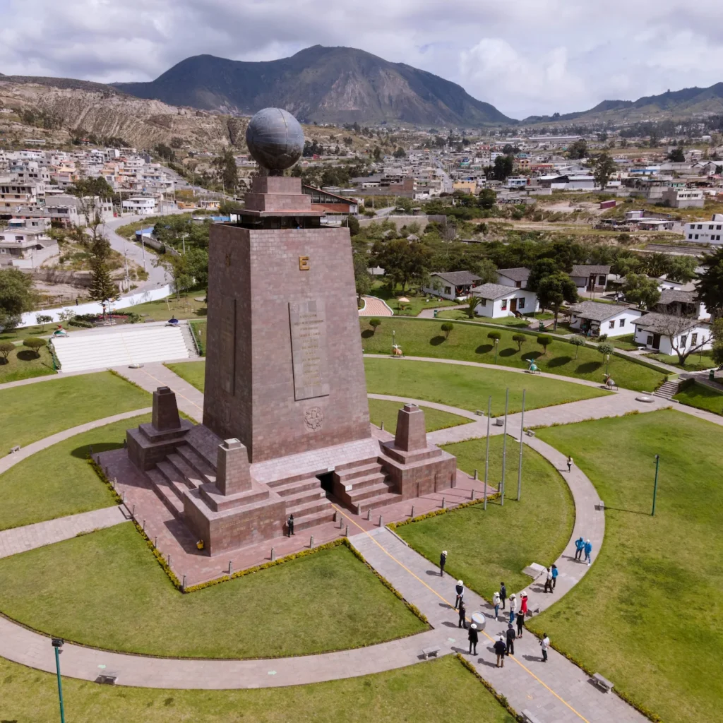 High-angle view of the large stone Mitad del Mundo monument topped with a metal globe in Ecuador