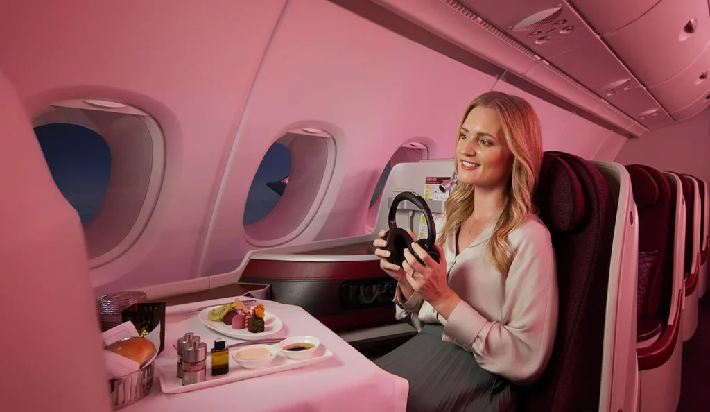 Woman at a business class seat with a dining tray in an airplane cabin