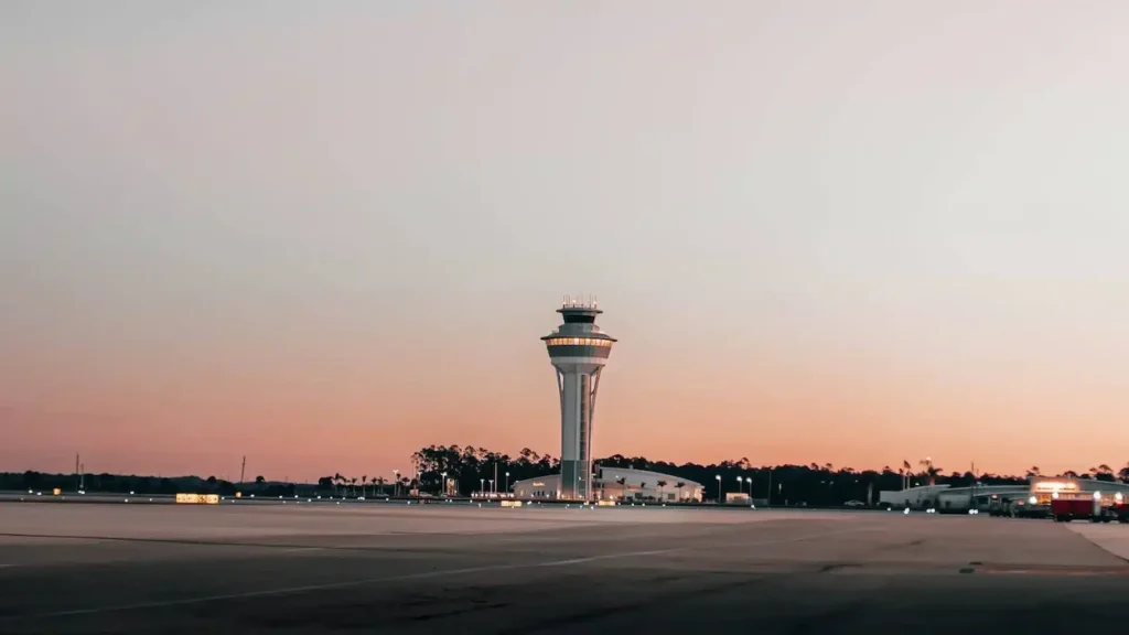 Air traffic control tower at Southwest Florida International Airport under a soft sunset sky