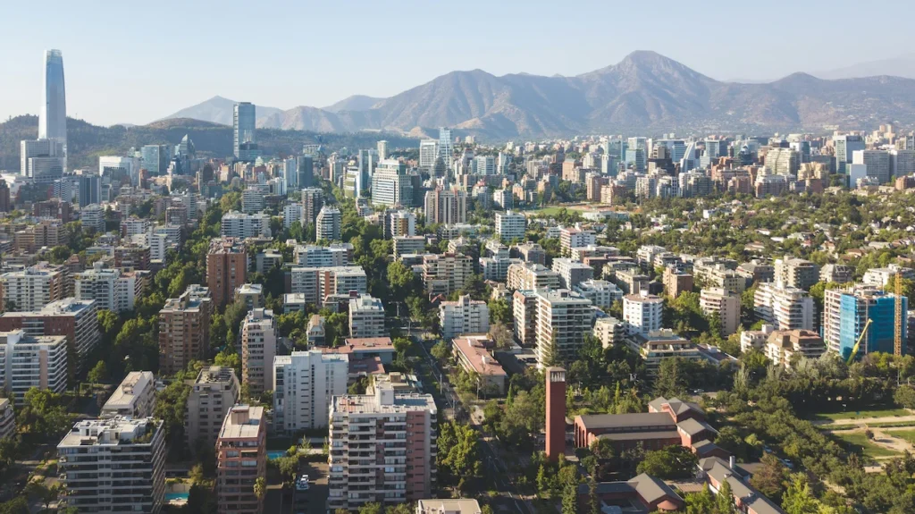 Aerial view of Santiago buildings and the tall Gran Torre Santiago skyscraper backed by massive mountains