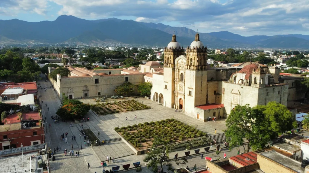 Aerial view of the Santo Domingo de Guzman church and plaza in Oaxaca Mexico with mountains behind
