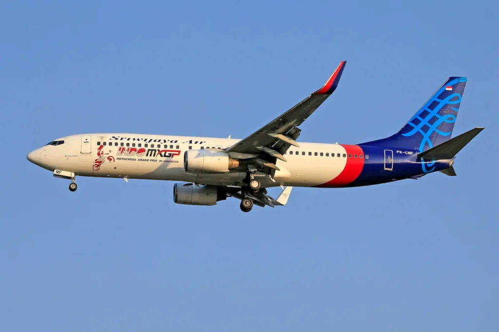 Sriwijaya Air Boeing 737 airplane landing in a clear blue sky
