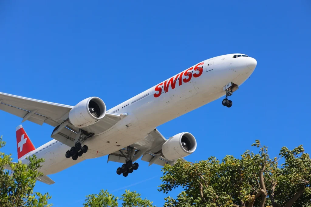 SWISS Boeing 777-300ER commercial passenger airliner descending for touchdown with landing gear deployed