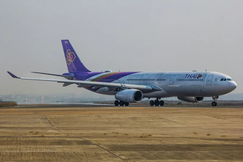 A Thai Airways Airbus A330-300 passenger airplane taxiing on a concrete taxiway