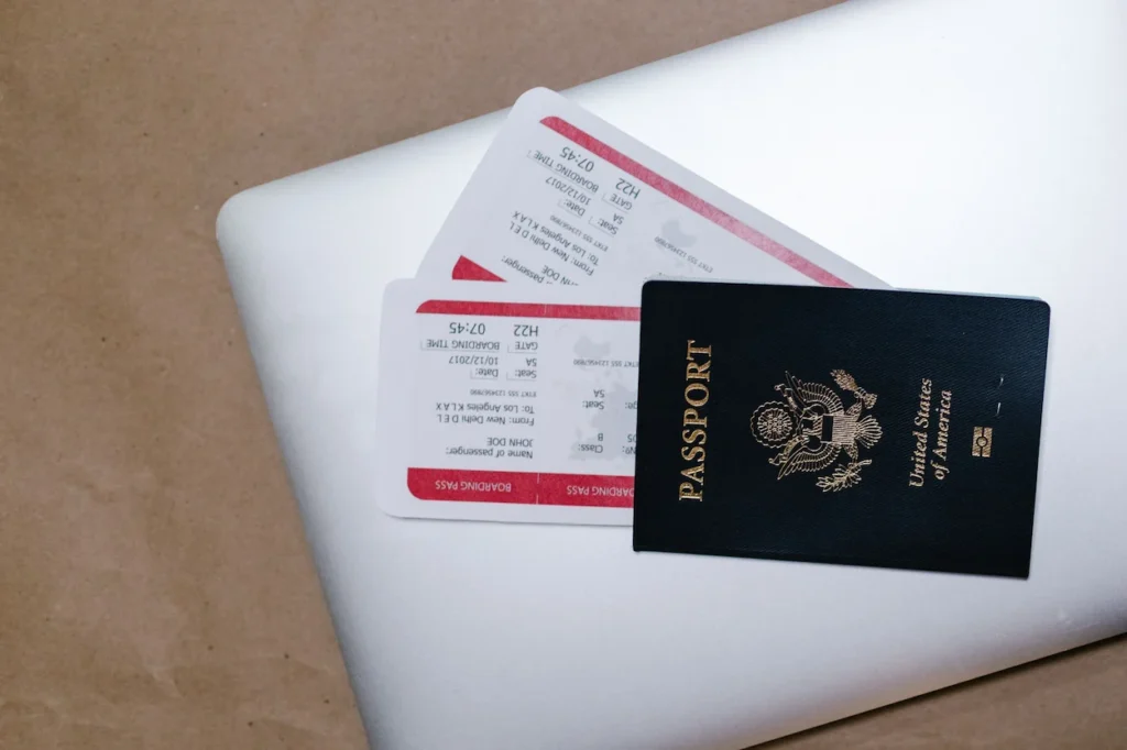United States passport and two boarding passes resting on top of a closed laptop