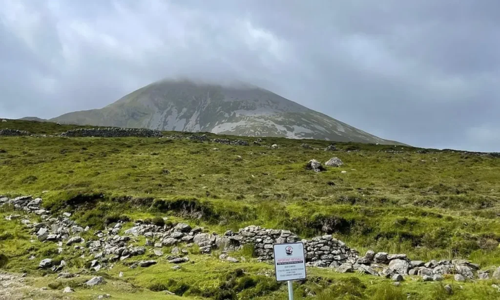 A misty peak rises above grassy slopes at Croagh Patrick.