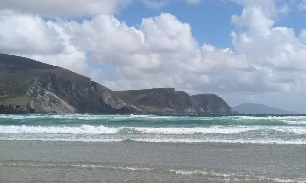 Waves crash onto the shore with cliffs in the background at Keel Beach.