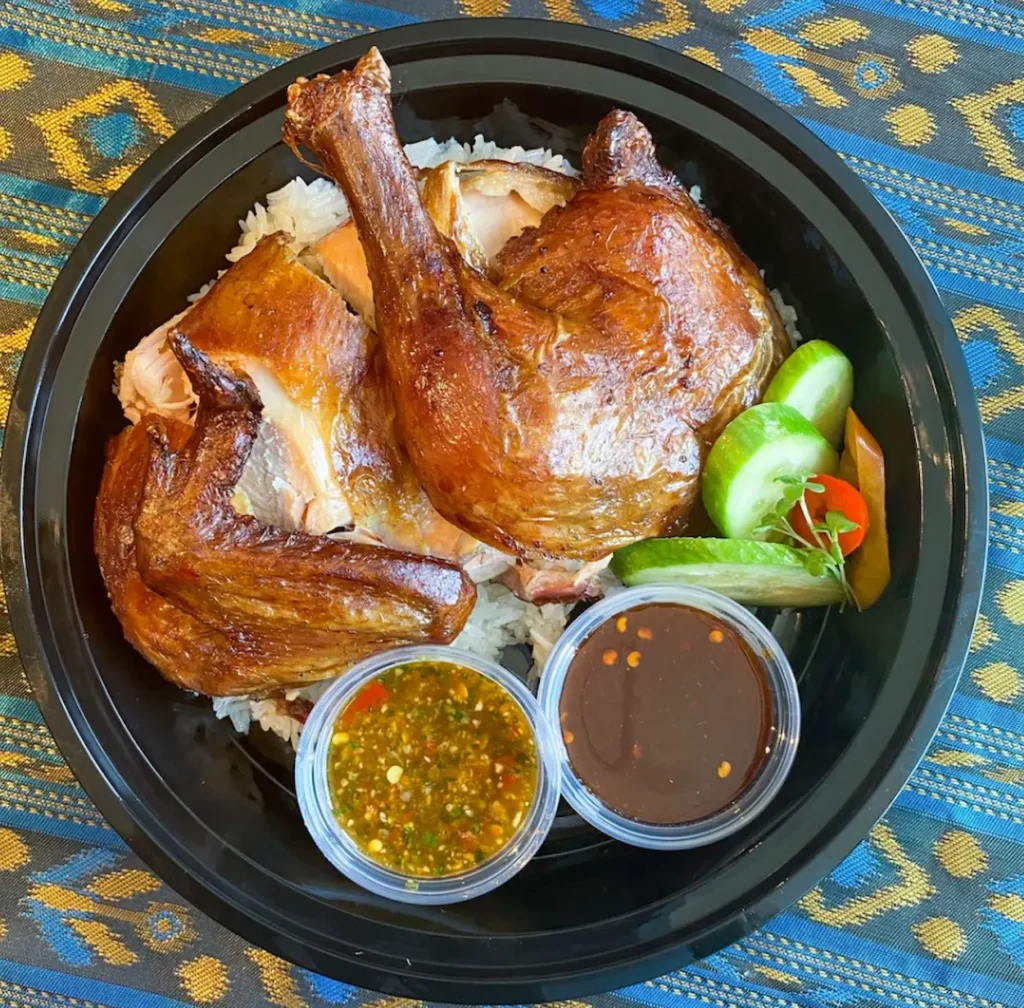 Rotisserie Chicken seasoned with Lemongrass & Coriander served with Seasoned Jasmine Rice, House Pickles, Tiger Cry Sauce & Thai BBQ Sauce