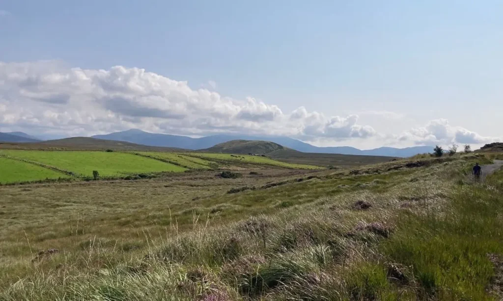 Rolling green fields stretch toward distant hills in Ballycroy National Park.