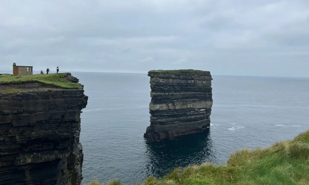A dramatic sea stack stands beside the cliffs at Downpatrick Head.