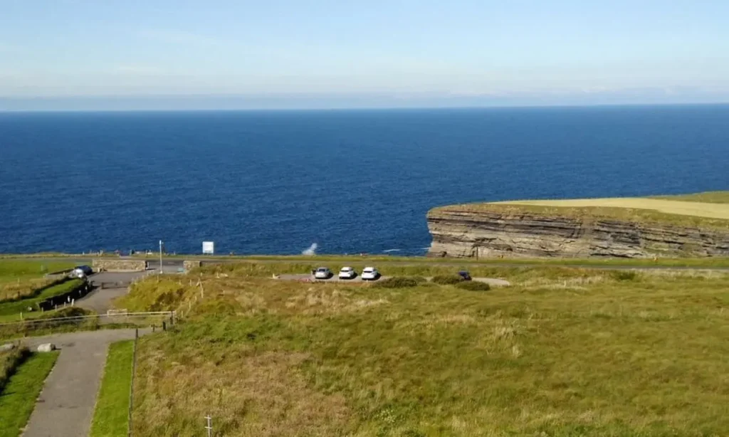 A grassy cliffside overlooks the ocean near Ceide Fields.