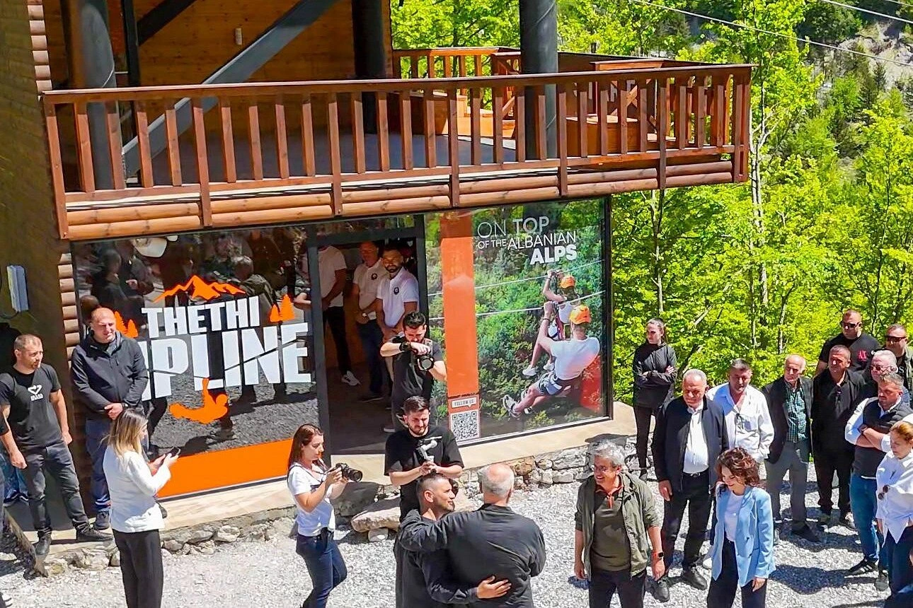 Theth zipline platform with tourists gathering around adventure activity station in Albanian Alps mountains