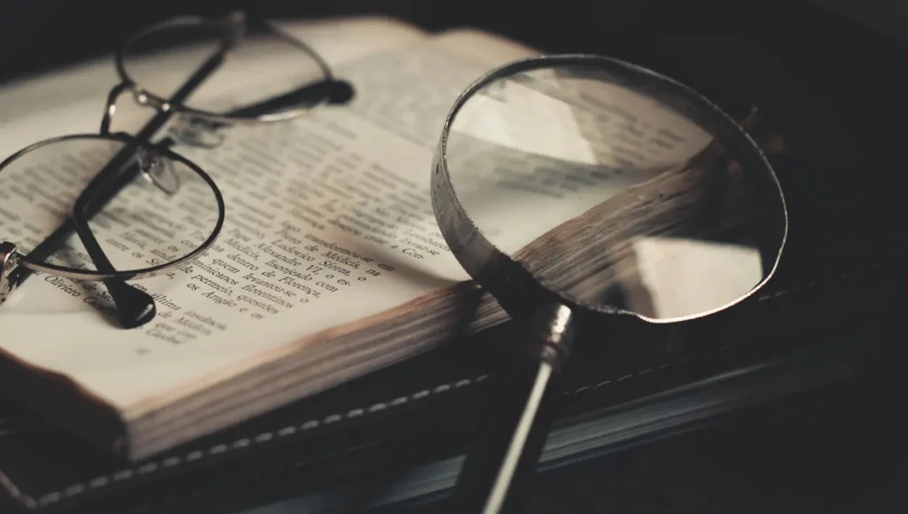 A magnifying glass, a book, and an eyeglass