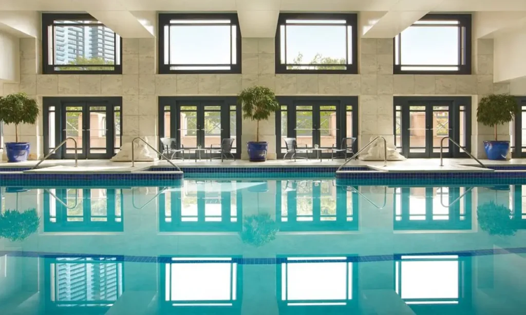 Indoor pool area with large windows and blue tile accents at Four Seasons Hotel Atlanta.