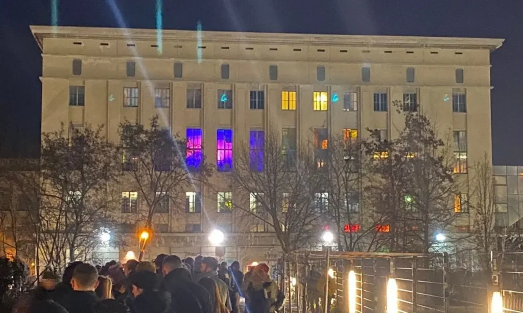 People line up outside the iconic Berghain nightclub in Berlin at night.