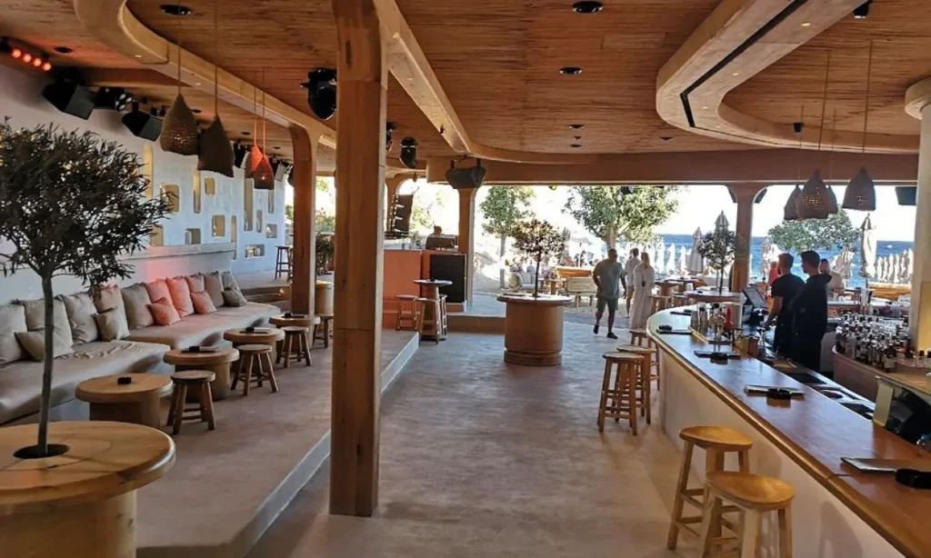 The open-air Super Paradise Beach Club features wooden décor and a view of the sea.