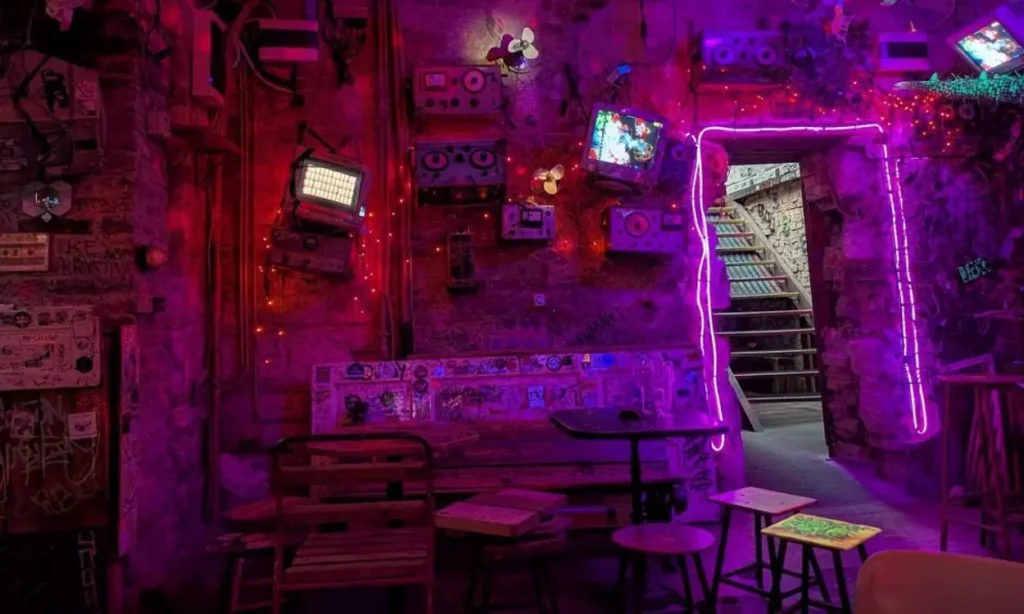 The eclectic interior of Szimpla Kert is lit with neon lights and decorated with vintage electronics.