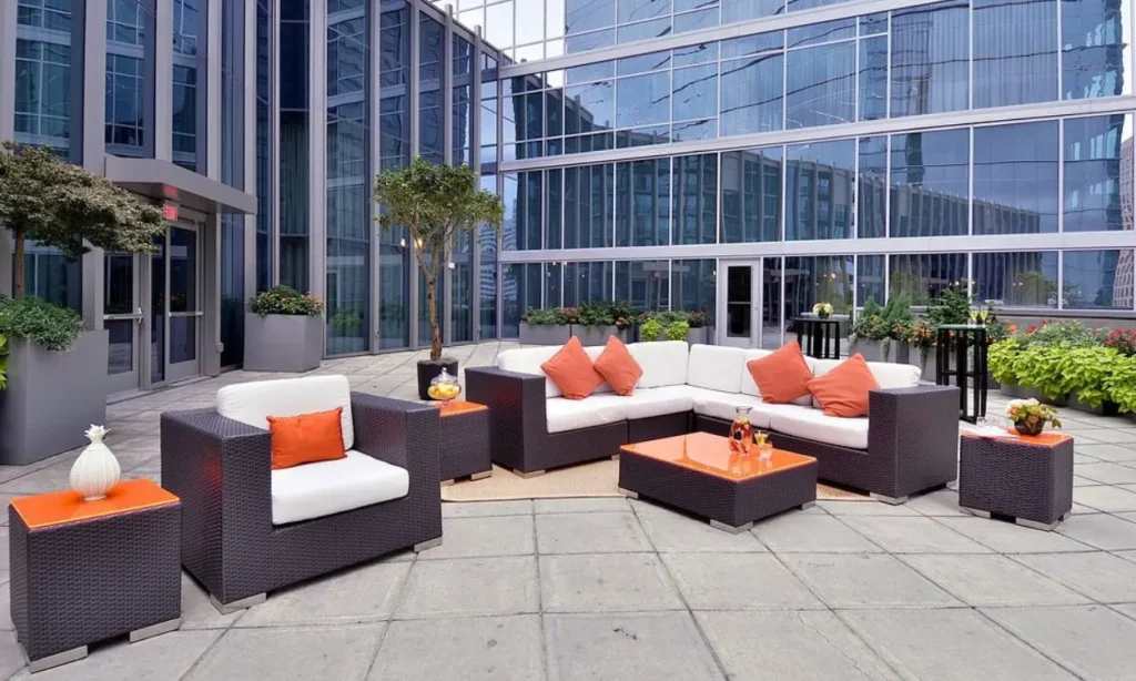 Modern outdoor lounge area with orange accents surrounded by glass buildings at Loews Atlanta Hotel.