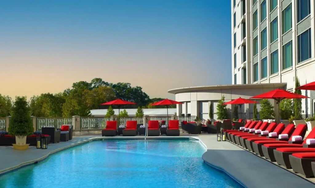 Outdoor pool lined with red umbrellas and lounge chairs at InterContinental Buckhead Atlanta.