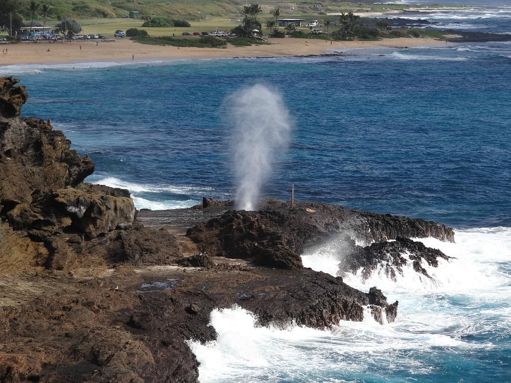 Ocean waves spraying water through the Halona Blowhole on the rocky coast.