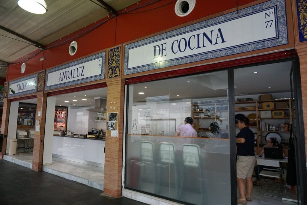 Entrance to Taller Andaluz de Cocina cooking school with people inside.