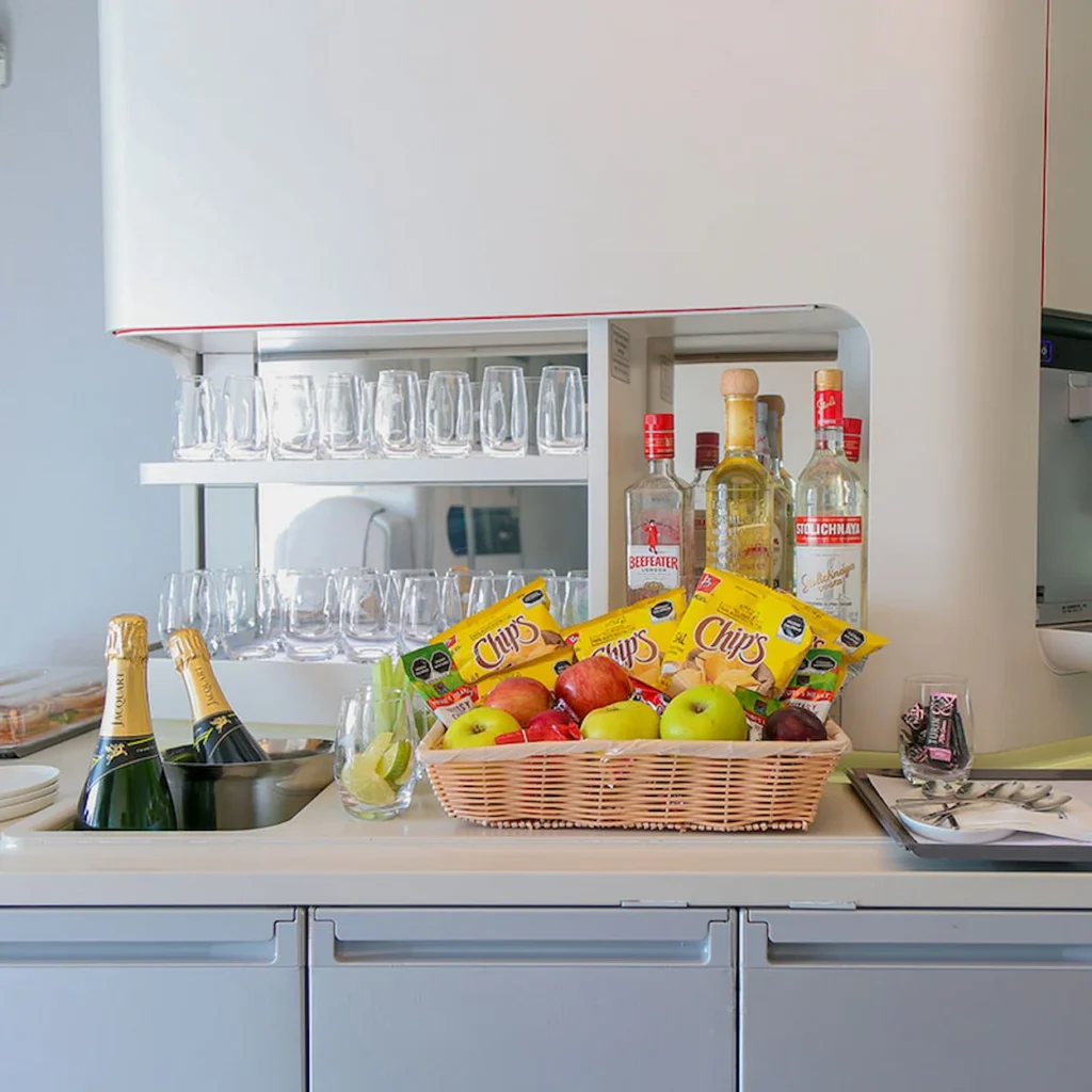 A buffet bar stocked with liquor bottles, snacks, and fresh fruit