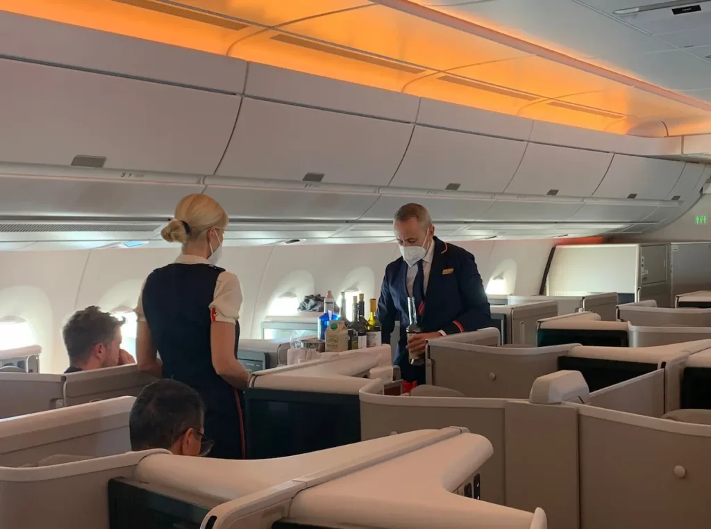 Inflight beverage trolley service proceeds through the wide aisles