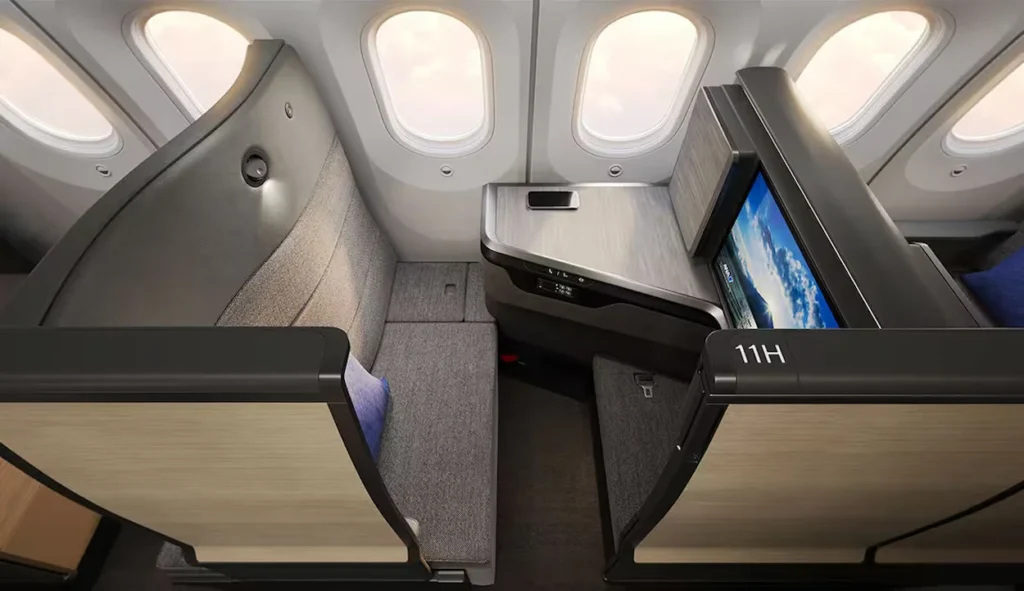 ANA business class suite 11H with a wide gray fabric seat by airplane windows