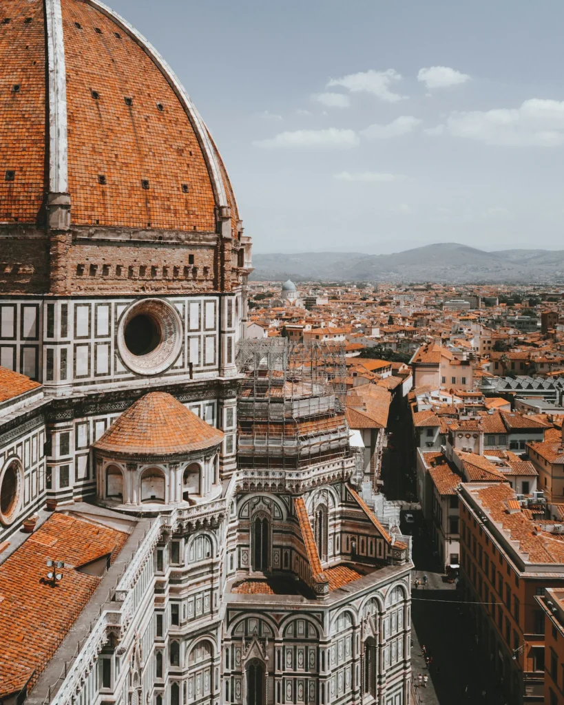 The large orange-tiled dome of the Florence Cathedral overlooking the surrounding cityscape in Italy