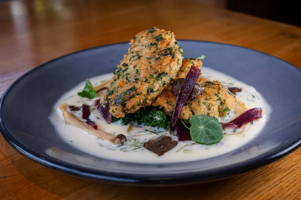 Hawaiian Airlines inflight meal featuring herb-crusted protein over greens in a cream sauce