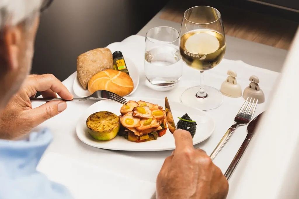 Iberia business class service includes multi-course regional dining options