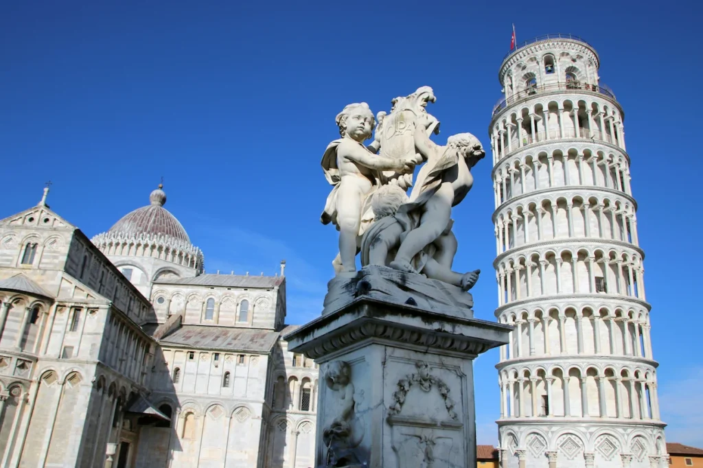 Leaning Tower of Pisa and Pisa Cathedral behind a marble cherub statue
