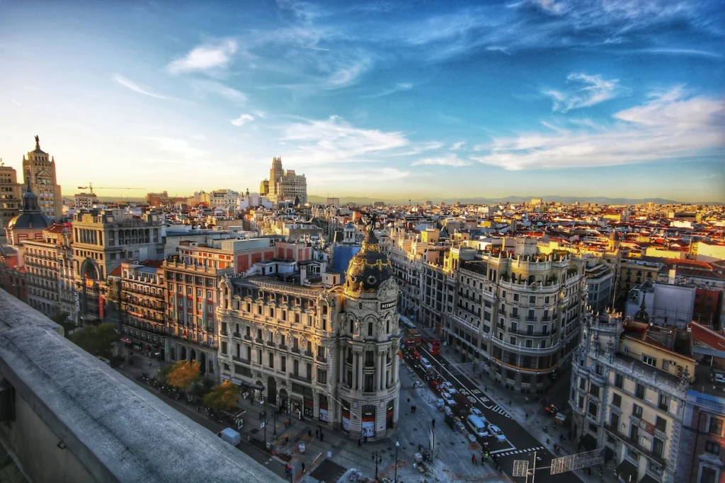 High-angle view of the iconic Metropolis Building and the historic Madrid cityscape at sunset
