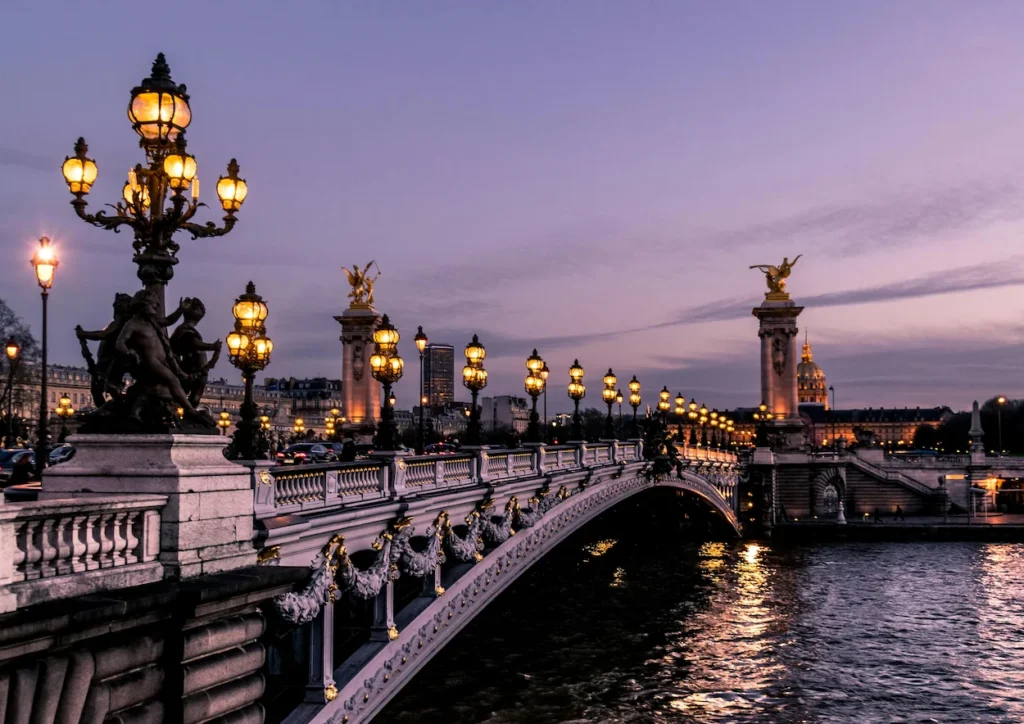 The illuminated Pont Alexandre III bridge crossing the Seine River in Paris