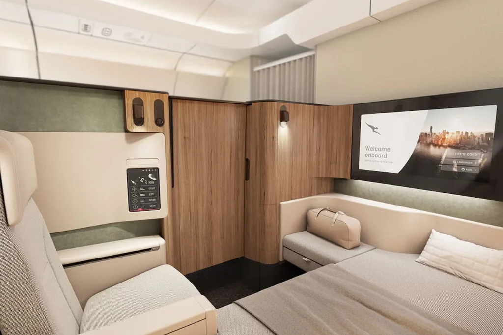 Premium airline first-class cabin suite featuring wood paneling and a bed