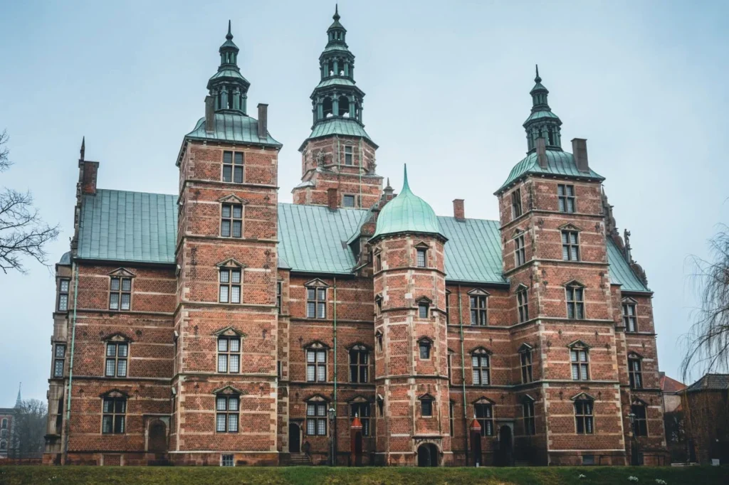 The brick facade and green spires of Rosenborg Castle in Copenhagen