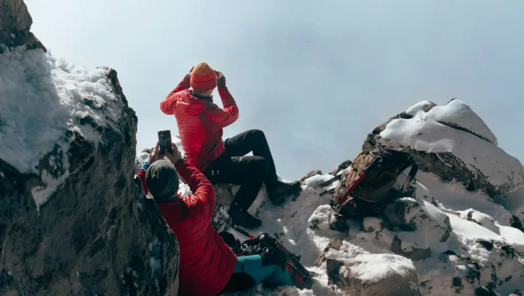 Two person on top of a mountain taking pictures