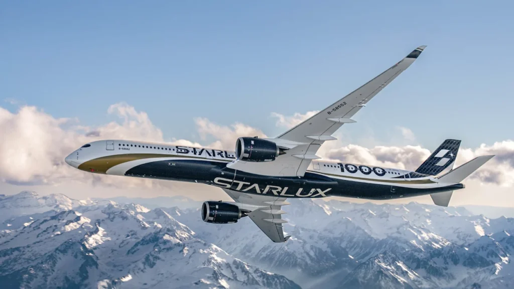 Starlux Airlines Airbus A350-1000 in custom black livery flying above snowy mountain peaks