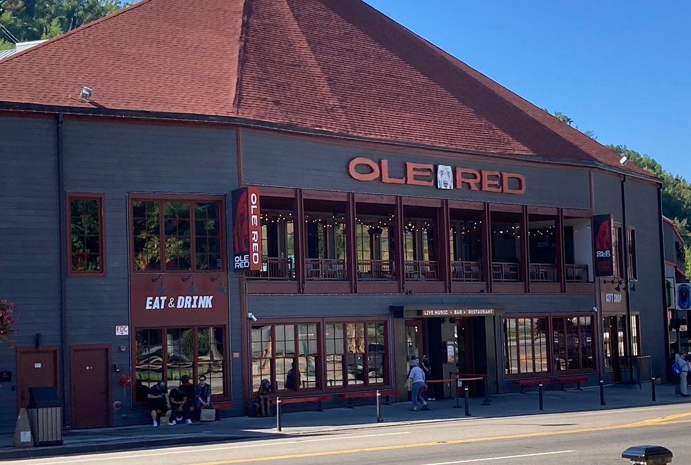 Front view of Ole Red restaurant and music bar with red roof and large sign.