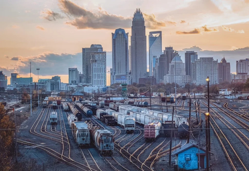 Charlotte skyline behind a busy train yard at sunset