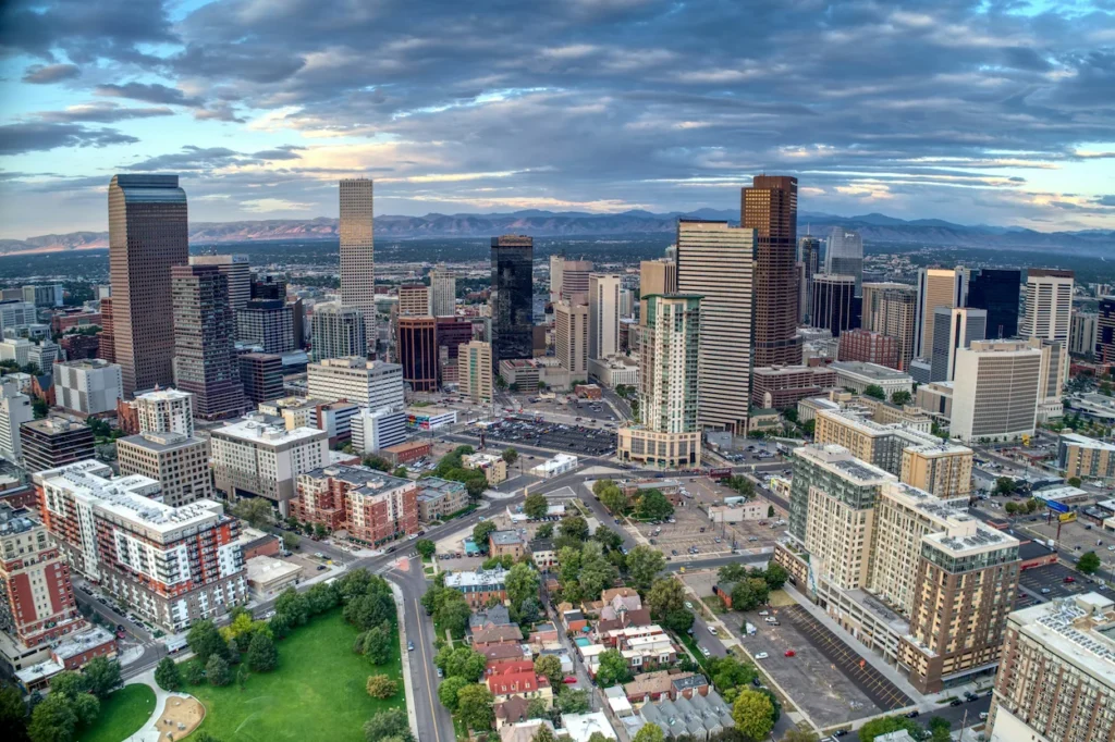 Downtown Denver skyline buildings with snow-capped Rocky Mountains in the background